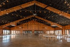 a large room with tables and chairs in it, all lit up by string lights