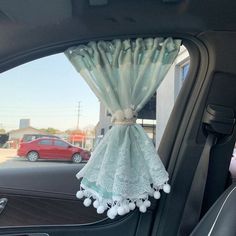 the interior of a car is decorated with lace and pom poms