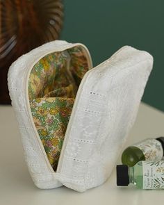 an open zippered pouch sitting on top of a table next to bottles and a lamp