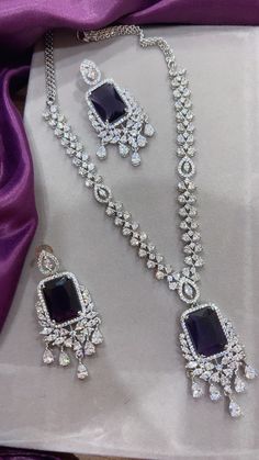 Gorgeous fine quality imitation jewellery  CZ Purple with CZ diamonds studded necklace with white gold rhodium plating and matching Earrings Item contains: Necklace and earrings AAA quality cubic zirconia used. Highest quality and craftsmanship Necklace Fitting is adjustable Earrings Closure: Pushback Necklace Closure: chain with Hook Details-  -Handmade item -Delivery from a small business in India -Materials: white rhodium, stones, cz, zircon, American diamond -Jewellery type: Earrings, Neckla Purple Stone Jewellery, Sterling Silver Dazzling Jewelry Sets, Elegant Silver Jewelry Sets With Cubic Zirconia, Exquisite Cubic Zirconia Jewelry Sets, Dazzling Cubic Zirconia Jewelry Set With Diamond Cut, Dazzling Sterling Silver Jewelry Sets With Elegant Design, Dazzling Cubic Zirconia Diamond Cut Jewelry Sets, Exquisite Cubic Zirconia Jewelry Sets In Diamond White, Silver Diamond Bridal Necklace With Gemstone