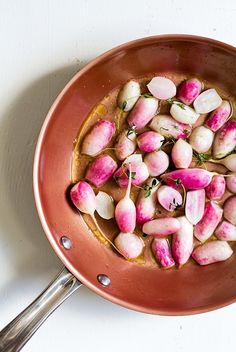 a pan filled with sliced up radishes on top of a white countertop