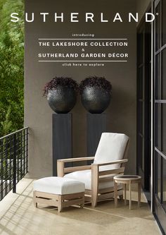 a white chair sitting on top of a wooden floor next to two black vases