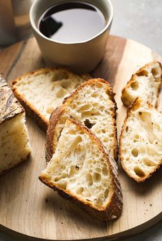 slices of bread on a cutting board next to a cup of coffee