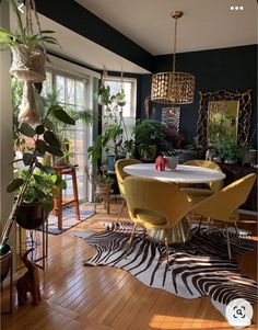 a dining room table surrounded by chairs and plants