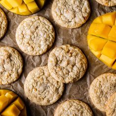 some cookies and mango slices are on a piece of wax paper