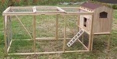 a large wooden chicken coop in the grass