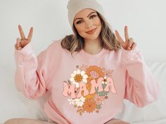 This groovy retro floral mama sweatshirt is the perfect birthday gift for mom or on any occasion! Available in a sweatshirt, hoodie or t-shirt     SIZING    * UNISEX sizing  * Please check the size chart in the listing photos for measurements. Size down for a tighter fit Normal size for loose comfy fit Size up for oversized.     HOW TO ORDER    2. Select your style, size and color from the drop down menus 3. Choose your quantity 4. Click ADD TO BASKET. You can then go back to add more sizes or colors. 5. Proceed to Checkout     CARE INSTRUCTIONS    * Wash inside out with like colors. * Tumble dry on low or hang to dry. * Iron on cool with shirt inside out. Do not iron directly over the design. * Do not dry clean     SHIPPING AND PRODUCTION TIME    READY TO SHIP IN 1-3 BUSINESS DAYS! Need y Mother's Day Pink Relaxed Fit Sweatshirt, Pink Relaxed Fit Sweatshirt For Mother's Day, Casual Pink Sweatshirt For Mother's Day, Casual Sweatshirt For Mother's Day Loungewear, Mother's Day Casual Sweatshirt With Custom Print, Mother's Day Graphic Print Sweatshirt, Womens Sweatshirts, Birthday Gift For Mom, Funny Mom Gifts