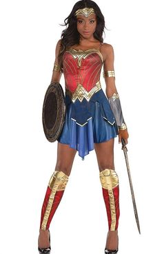 a woman dressed in a wonder costume holding two swords and a shield with both hands