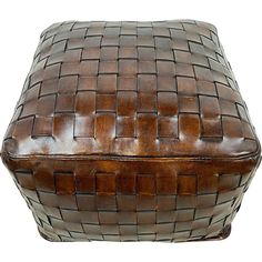 a large brown leather basket sitting on top of a white floor