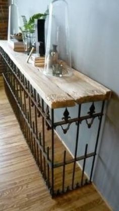 a long wooden table sitting on top of a hard wood floor next to a wall