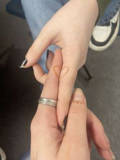 two people holding each other's hands with their fingers