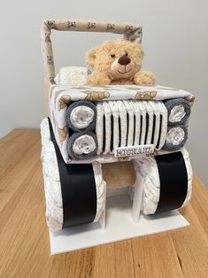 a teddy bear is sitting in the back of a car made out of diapers