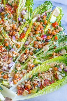 lettuce salad with chickpeas, carrots and other toppings on a white plate