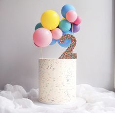 there is a birthday cake with balloons in the shape of number two on top of it