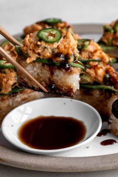 food on a plate with chopsticks and sauce