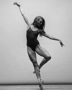 a black and white photo of a woman in a leotard with her arms outstretched