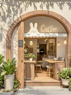 an entrance to a coffee shop with potted plants