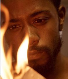 a close up of a person holding a piece of paper with fire coming out of it