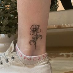 a small flower tattoo on the ankle