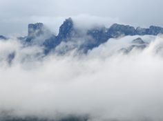 the mountains are covered in thick clouds on a foggy day with no one visible