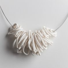 a white necklace is hanging on a string