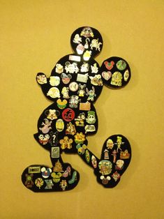 a mickey mouse made out of many different types of magnets on a yellow wall