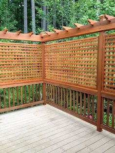 a wooden deck with trellis on it and trees in the backgroung