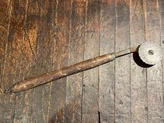 an old tool is laying on the wooden floor with it's blade missing from its end