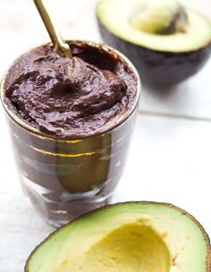 an avocado cut in half next to a chocolate smoothie