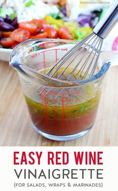 the ingredients for easy red wine vinaigrette in a glass measuring cup with a whisk