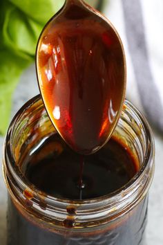 a spoon full of syrup being poured into a jar