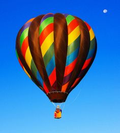 a colorful hot air balloon flying in the blue sky