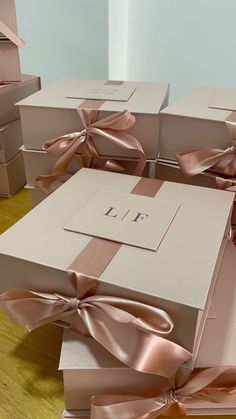 several boxes with pink bows on them sitting on a wooden floor next to each other