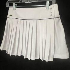 About This Product This Tennis Core Lightweight And Stretchy, Pleated Skirt With Mesh Back Waistband Is A Blend Of Tradition And Innovation To Help You Perform In Style. Wrap Style. Cute Tennis Skirt With Button Closure On Side. Material: 93% Polyester, 7% Elastane Color: White, Black Tennis//Pickleball/Padel Preppy Tennis Skort For Spring, Preppy Spring Tennis Skort, White Fitted Skort For Golf, Classic White Tennis Skirt, White Fitted Tennis Skirt For School Uniform, Casual White Tennis Dress With Lined Skirt, White Golf Skort For Spring, White Pleated Tennis Skirt In Preppy Style, White Preppy Skort