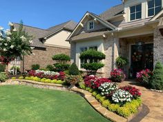 a house with landscaping and flowers in the front yard