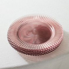 a pink glass bowl sitting on top of a table