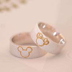 two wedding rings with gold mickey ears on them