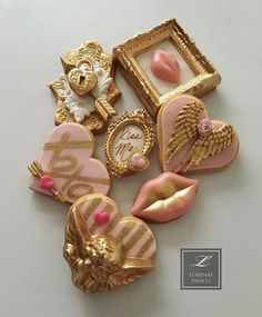 some pink and gold brooches are laying on a white surface with other items