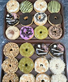 two trays filled with different kinds of donuts