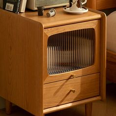 a radio sitting on top of a wooden cabinet next to a bed