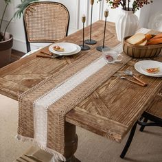 a wooden table topped with plates and glasses