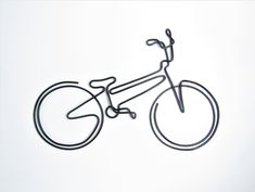 a wire sculpture of a bicycle on a white background with the outline of a person's head