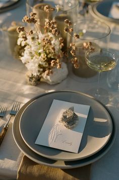 the table is set with silverware and place settings