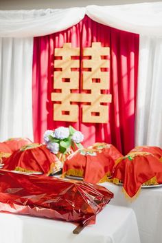 the table is set up with red cloths and gold decorations on top of it