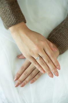 a close up of a person's hands with a wedding ring on their finger