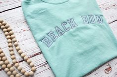 the beaded necklace is next to a t - shirt that says beach bum on it