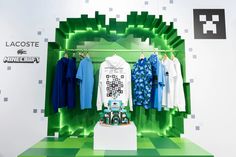 an exhibit with clothes on display in front of a green and white wall that says lacoste