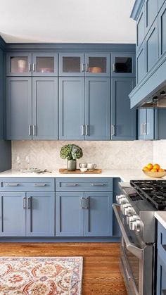 a kitchen with blue cabinets and an area rug on the floor in front of it