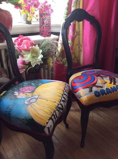 there are two chairs that have been decorated with cartoon characters on them and flowers in the window sill