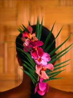 a woman with flowers in her hair is looking down at the floor and wood paneled wall